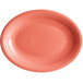 An Acopa Capri coral oval stoneware coupe platter with a white background and pink rim.