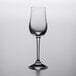 A clear Stolzle port wine glass on a white surface.