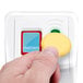 A hand pressing a yellow button on a white Barska biometric security lock device.
