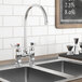 A Waterloo deck mount faucet with gooseneck spout and 4" centers on a sink with a black board above it.
