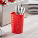 A red plastic flatware holder with silverware in it.
