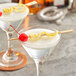 A pair of martini glasses with a cherry and lemon garnish using Bamboo by EcoChoice bamboo paddle skewers.
