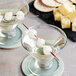 A pair of martini glasses with cheese skewers on them.