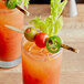 Two glasses of drinks garnished with tomatoes and celery on TreeVive by EcoChoice willow flat skewers.