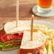 A sandwich on a plate with a TreeVive by EcoChoice Willow Flat Food Pick.