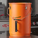 An orange Fryclone utility pail with a lid.