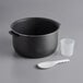 A black pot with a white plastic cup and a plastic spoon.