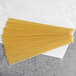 A pile of Barilla Thin Spaghetti noodles on a white surface.