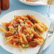 A plate of Barilla Penne Rigate pasta with sauce and a fork.