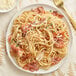A plate of Barilla whole grain spaghetti with bacon and pine nuts.