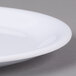 A close-up of a white Carlisle Melamine salad plate with a narrow rim.