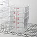 Cambro CamSquares Classic clear polycarbonate food storage containers on a rack.
