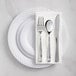 A white Visions plastic plate with silver Classic flatware on it.