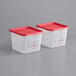 Two Carlisle clear plastic food storage containers with red lids.