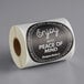 A roll of black TamperSafe paper labels with the words "Enjoy With Peace Of Mind" on them.