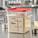 A Vigor clear square polycarbonate food storage container with red lid and rice inside.