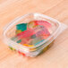 A Genpak clear plastic deli container filled with colorful gummy candies.
