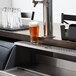 A stainless steel beer drip tray under a beer tap on a counter.