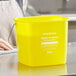 A close-up of a yellow Noble Products King-Pail on a table with white text on it.