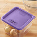 A purple Carlisle polypropylene lid on a container of onions.