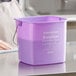 A close-up of a Noble Products purple sanitizing pail with a handle.