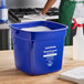 A blue Noble King-Pail 10 quart multi-purpose cleaning pail filled with soapy water.