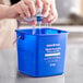 A person using a blue Noble Products King-Pail to wash a cloth.