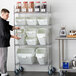 A man standing in front of a white shelf with white Baker's Lane ingredient bins.