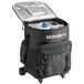 A black cooler bag with wheels and a telescoping handle.