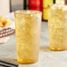 Two glasses of iced tea in amber pebbled tumblers with ice.