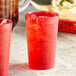 Two red Choice plastic tumblers with ice and a drink.