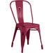 A red metal Lancaster Table & Seating outdoor cafe chair.