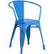 A Lancaster Table & Seating distressed blue metal arm chair on an outdoor patio.