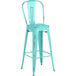 A turquoise metal outdoor barstool with a backrest.