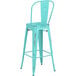 A seafoam metal barstool with a backrest.