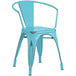A Lancaster Table & Seating blue metal outdoor arm chair with black legs.