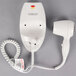 A white Conair wall mount hair dryer with a cord.