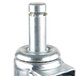 A close-up of a metal MetroMax iQ swivel stem caster with a round metal cap and a screw.
