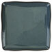 A square midnight blue porcelain plate with a speckled surface.