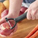 A person using a Choice 6" Smooth "Y" Peeler to peel a potato.