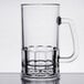 A clear plastic beer mug with a handle.