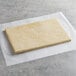 A rectangular piece of Pillsbury Danish pastry dough on a white paper surface.