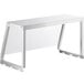 A white table with metal legs and a clear angled sneeze guard on top.
