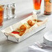 A Tablecraft rectangular stainless steel tray with food on it.