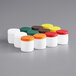 A group of white Carlisle Store N' Pour containers with assorted color lids.
