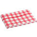 A red textured gingham vinyl table cover with a white checkered pattern on a table.