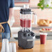 A Hamilton Beach commercial blender with a red smoothie in a Tritan jar.