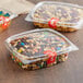 A group of Choice plastic deli containers filled with trail mix with nuts and candy.
