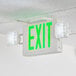 A white ceiling with a Lavex green exit sign with a white light.