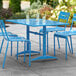 A blue Lancaster Table & Seating outdoor table with chairs on a patio.